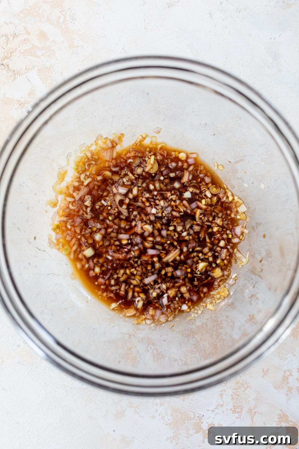All ingredients for the finishing sauce combined in a glass bowl.