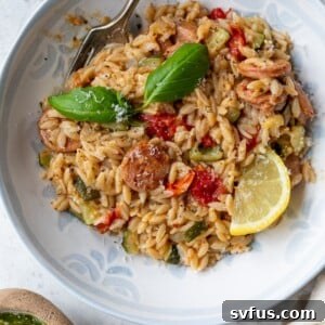 chicken sausage orzo in a bowl with a fork