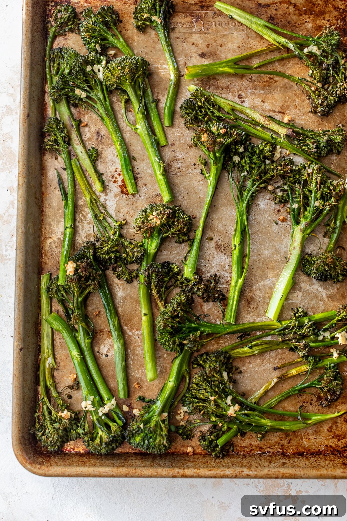 Perfectly roasted broccolini, golden and tender, spread on a baking sheet fresh from the oven.
