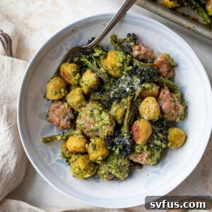 A delicious bowl of Sheet Pan Gnocchi with sausage and broccolini, garnished with fresh basil and parmesan.