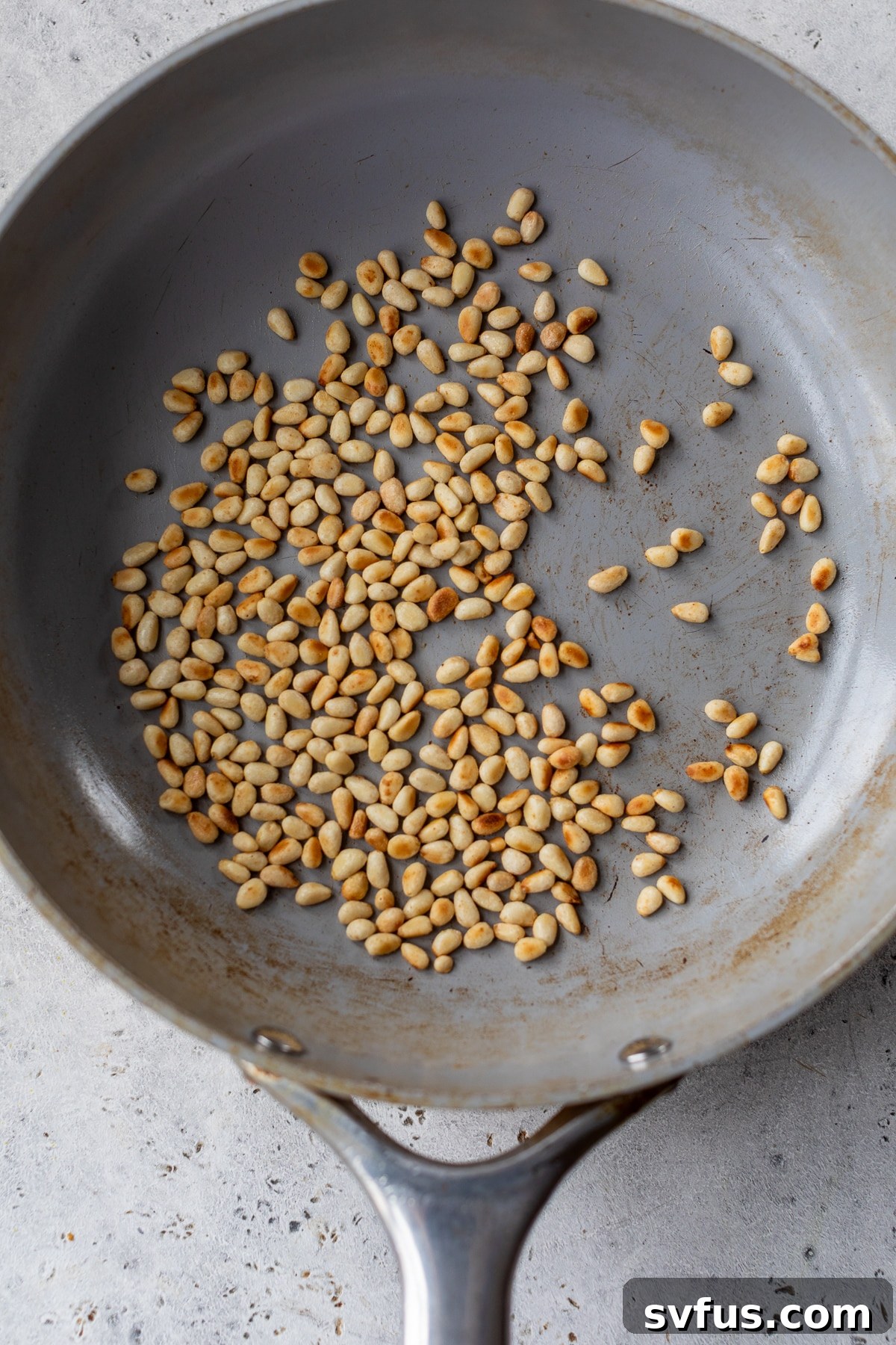 pine nuts toasting in a skillet