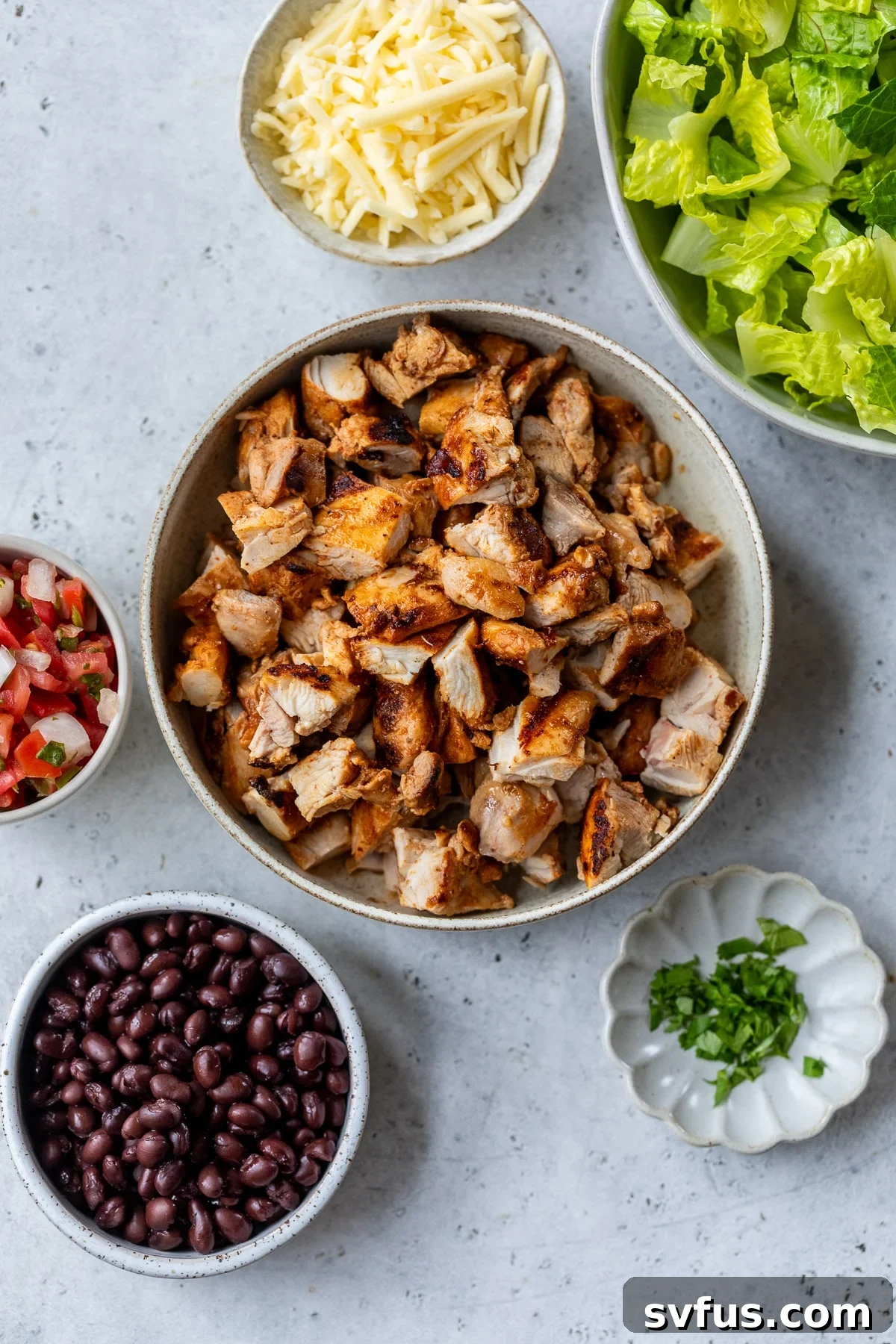 Individual bowls showcasing the fresh ingredients needed for Grilled Chipotle Chicken bowls, including spices, lime, and chicken.