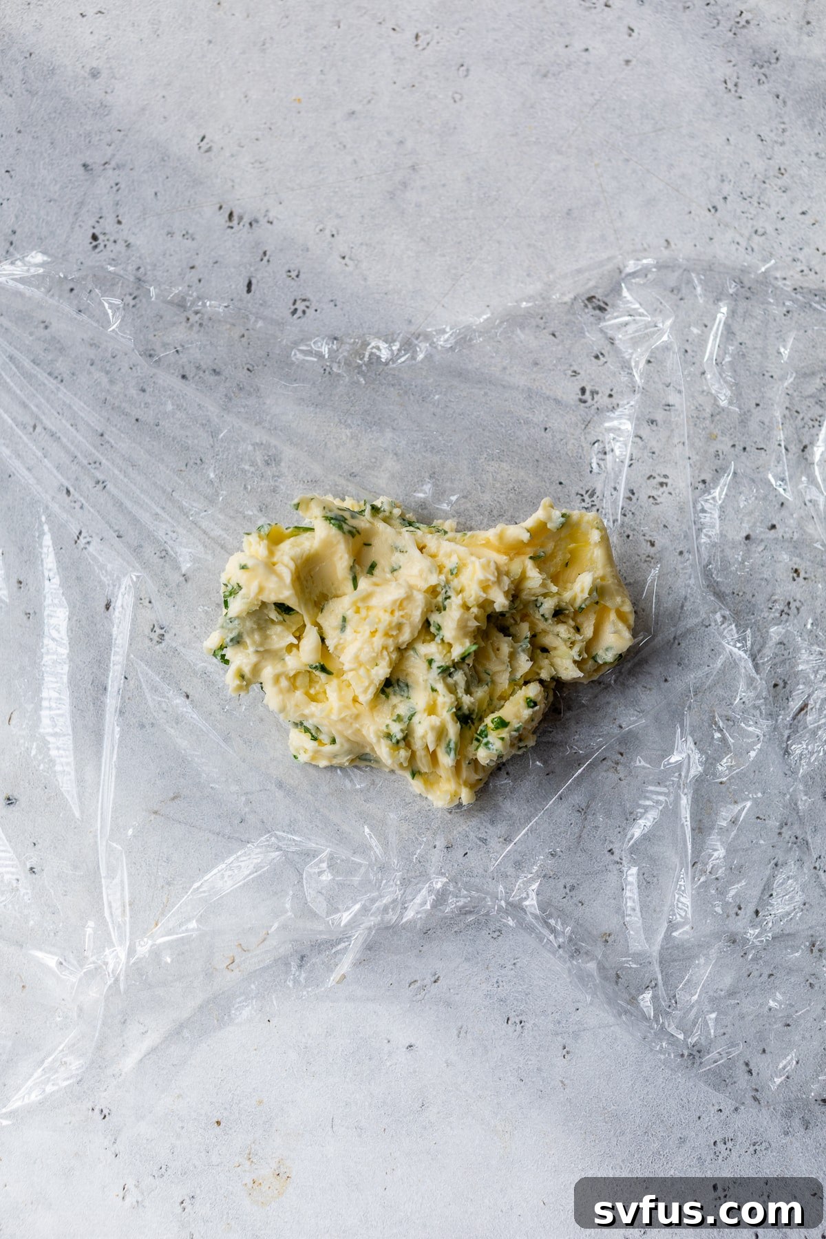 garlic butter placed in the center of plastic wrap