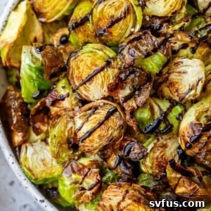 air fryer brussels sprouts in a bowl with balsamic vinegar drizzled overtop