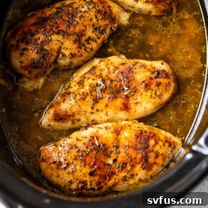 chicken breasts cooking in a slow cooker.