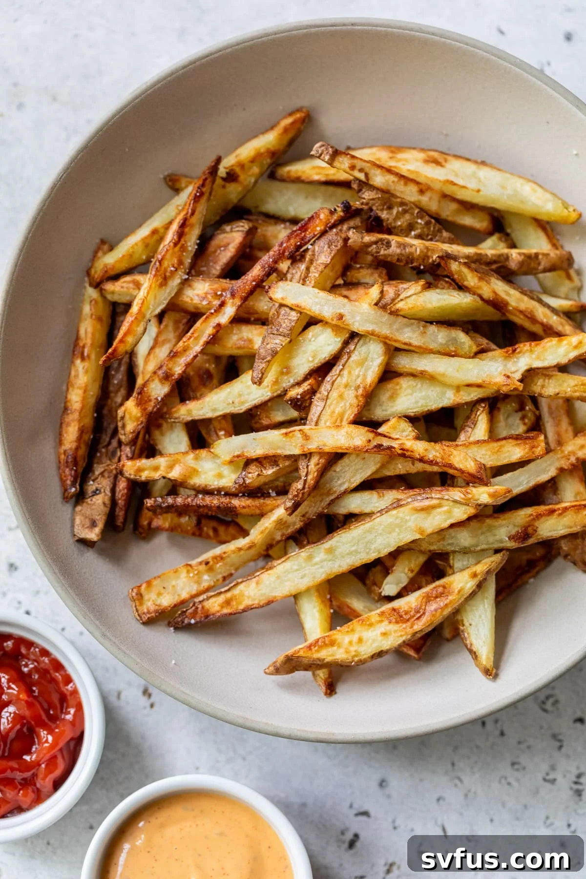 A bowl of perfectly golden and crispy air fryer french fries, ready to be enjoyed.