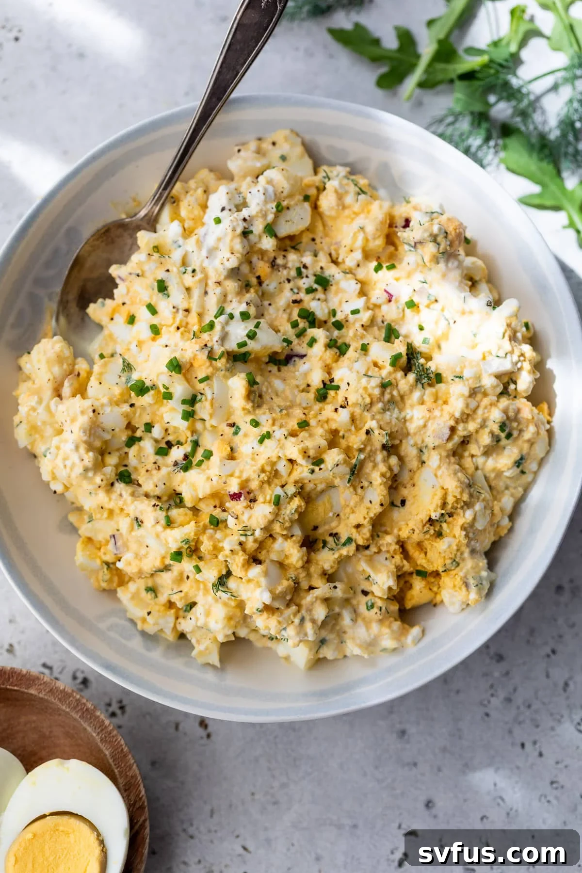 A large white bowl filled with creamy, herb-flecked Cottage Cheese Egg Salad, ready to be served.