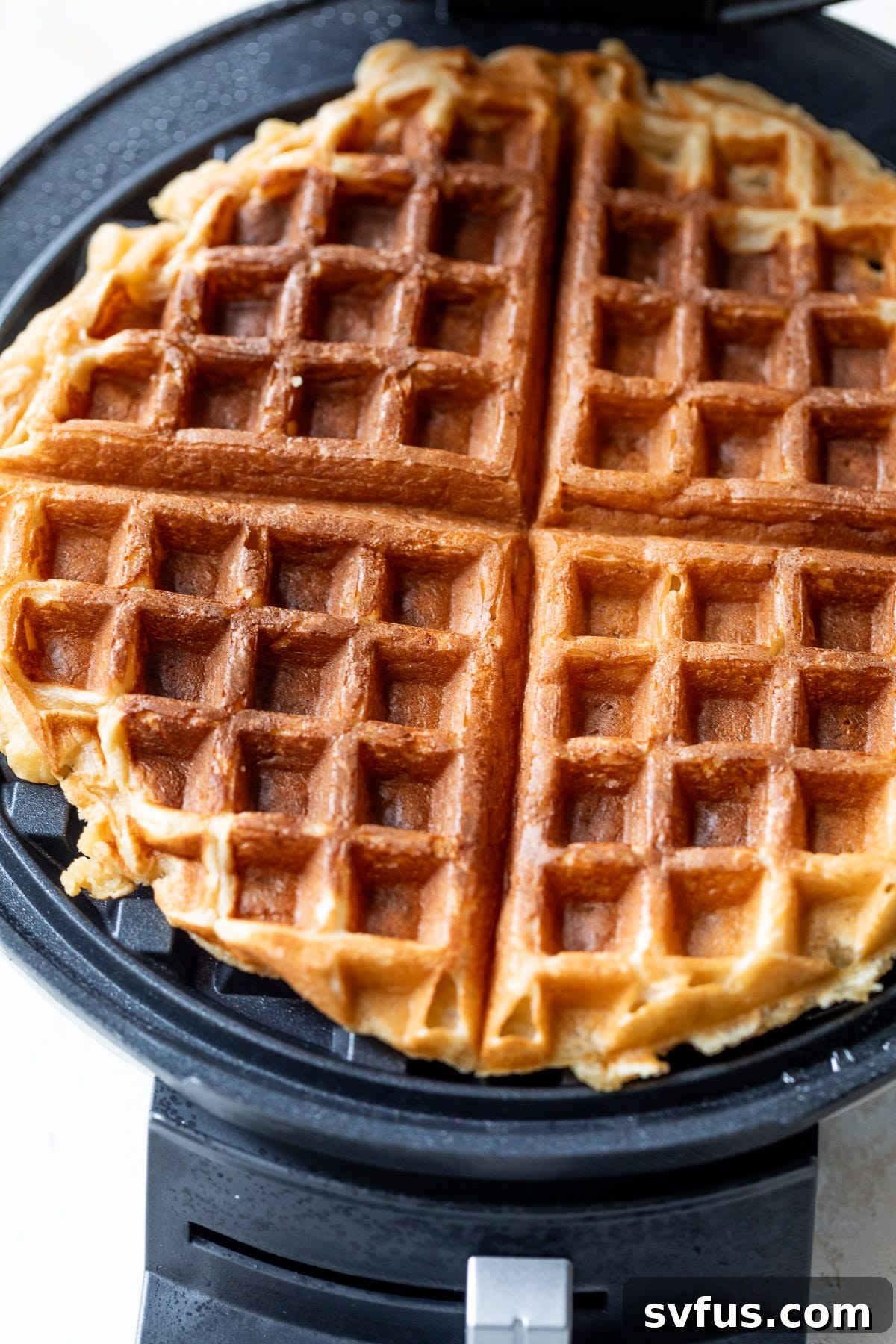 a protein waffle cooking on a waffle iron.