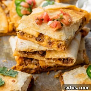 Close up on a stack of sheet pan quesadillas topped with salsa.