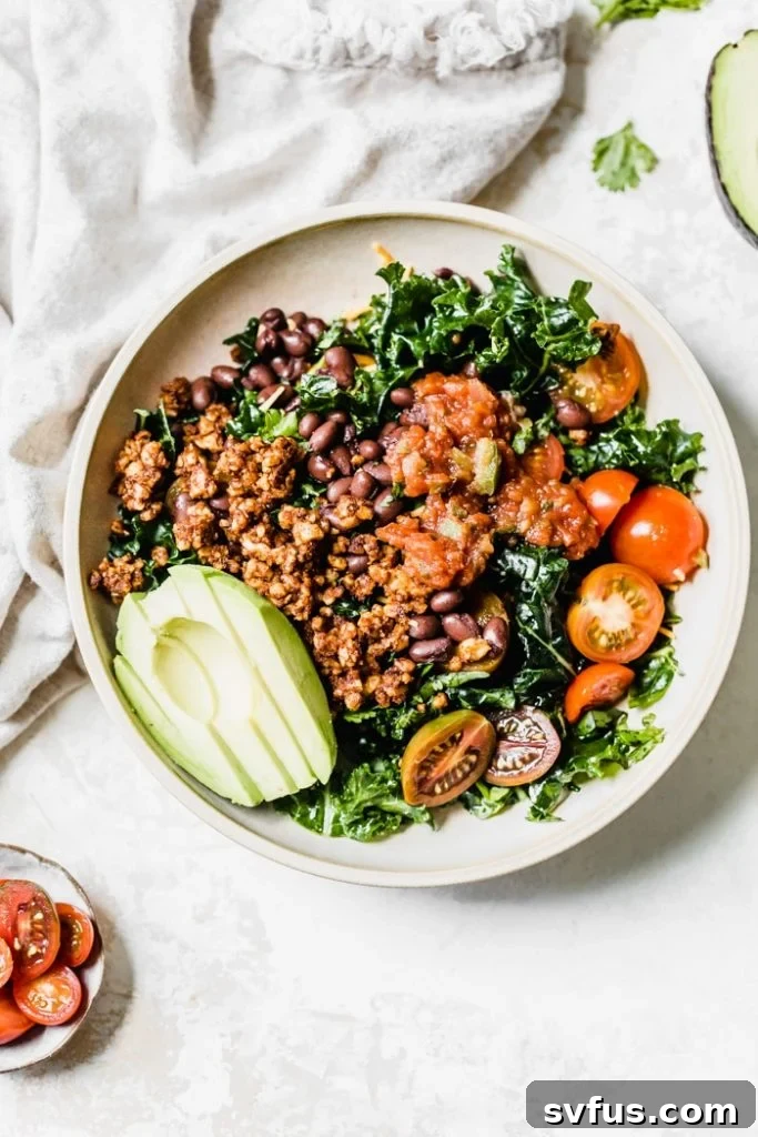 Kale salad topped with avocado, tomatoes and black beans