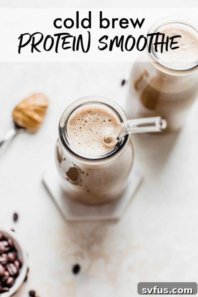 A tall glass of cold brew protein smoothie, garnished with coffee beans and a drizzle of peanut butter, sitting on a rustic wooden table.