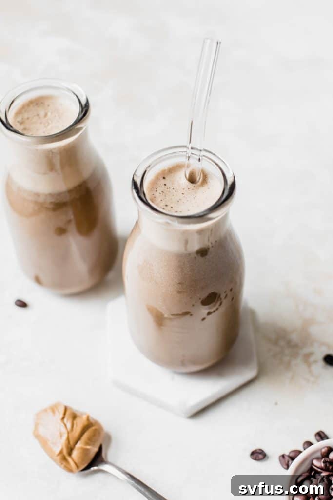 A beautifully presented, filling protein smoothie made with coffee, served in a glass with a straw.