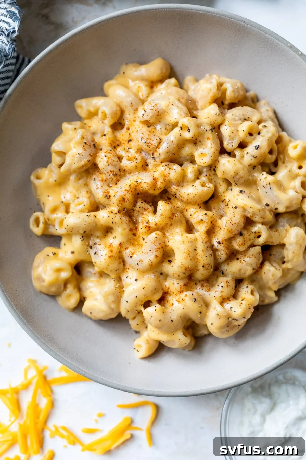 overhead view of a bowl filled with high-protein cottage cheese mac and cheese, garnished with a sprinkle of paprika.