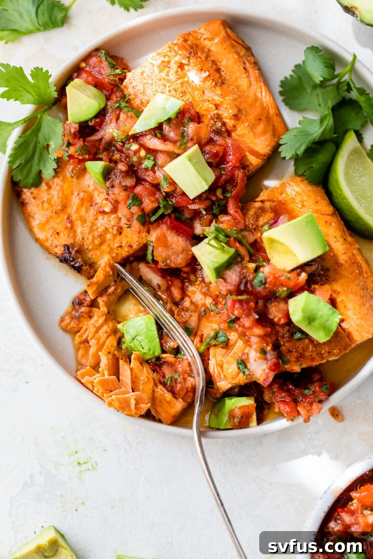Two seared salmon fillets beautifully plated and generously topped with a rich, colorful chipotle salsa, highlighting the vibrant ingredients.