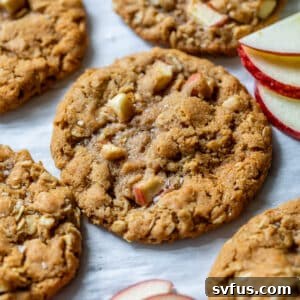 Close up on baked apple oatmeal cookies next to thin apple slices, showcasing the texture.