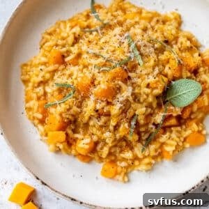 A tempting image of Butternut Squash Risotto on a plate, adorned with fresh sage leaves and grated Parmesan cheese, ready to be enjoyed.