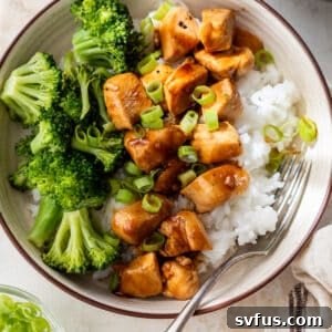 Teriyaki chicken and broccoli served over white rice in a bowl, ready for a delicious meal.