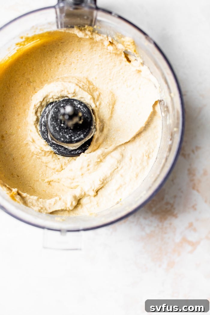 Creamy hummus being blended in a food processor, showing the smooth texture and process.