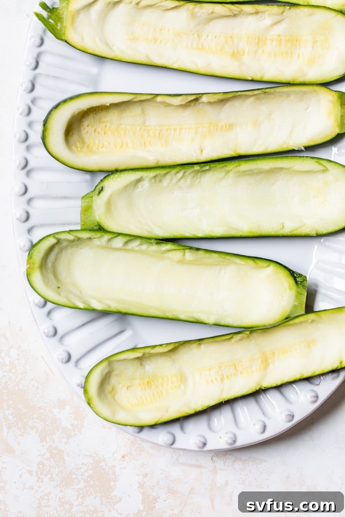 Zucchini with the inside scooped out, ready for stuffing