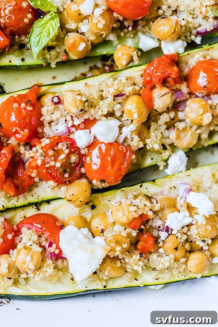 Zucchini boats generously filled with quinoa, tomatoes, and feta cheese, ready for baking