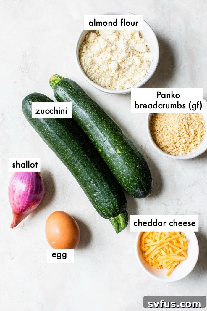 a variety of fresh ingredients for zucchini fritters including zucchini, egg, shallot, and cheese, neatly arranged on a table with a text overlay