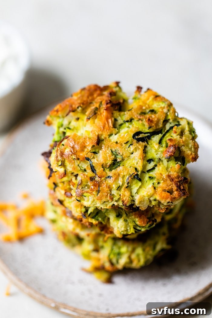 a beautifully plated stack of crispy baked zucchini fritters, ready to be served and enjoyed