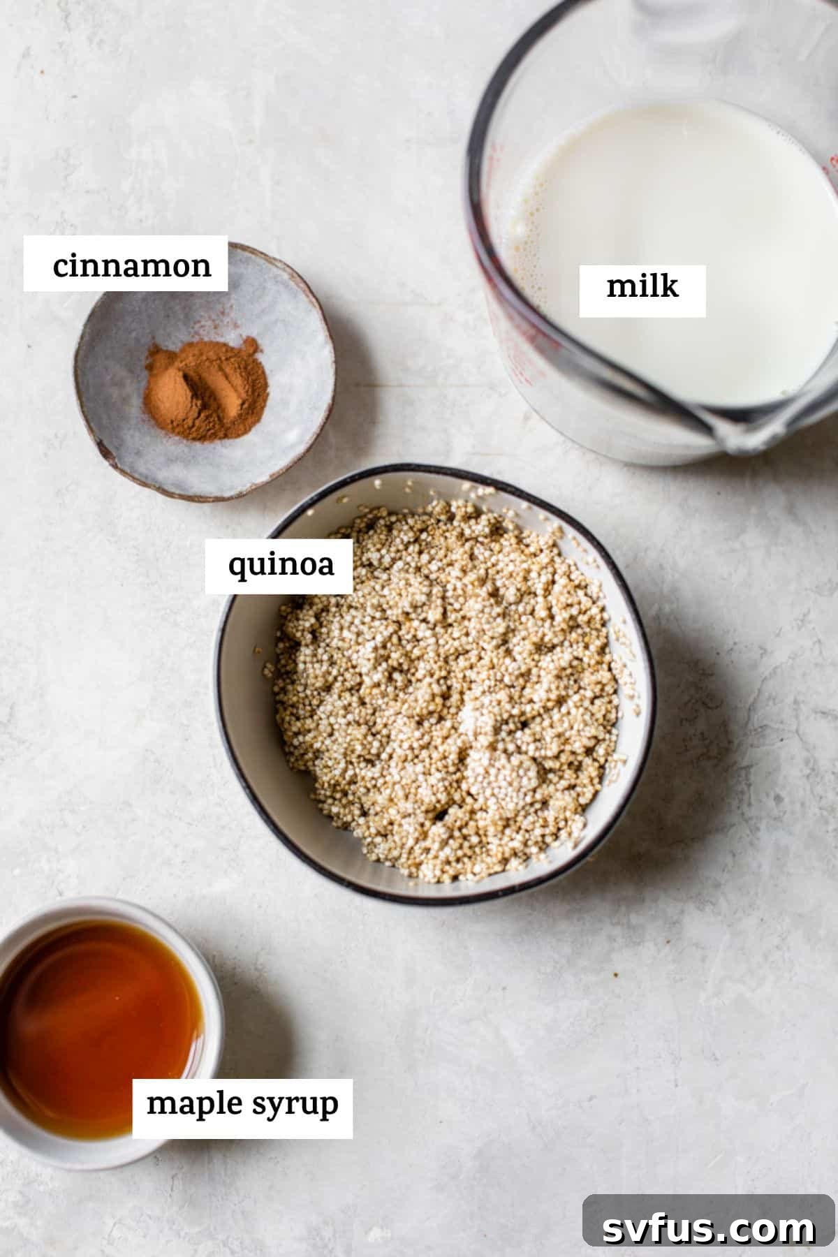 Close-up shot of key ingredients like dry quinoa grains, a carton of milk, and cinnamon sticks, with a focus on their quality.