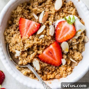 A bowl of quinoa topped with sliced strawberries and almonds