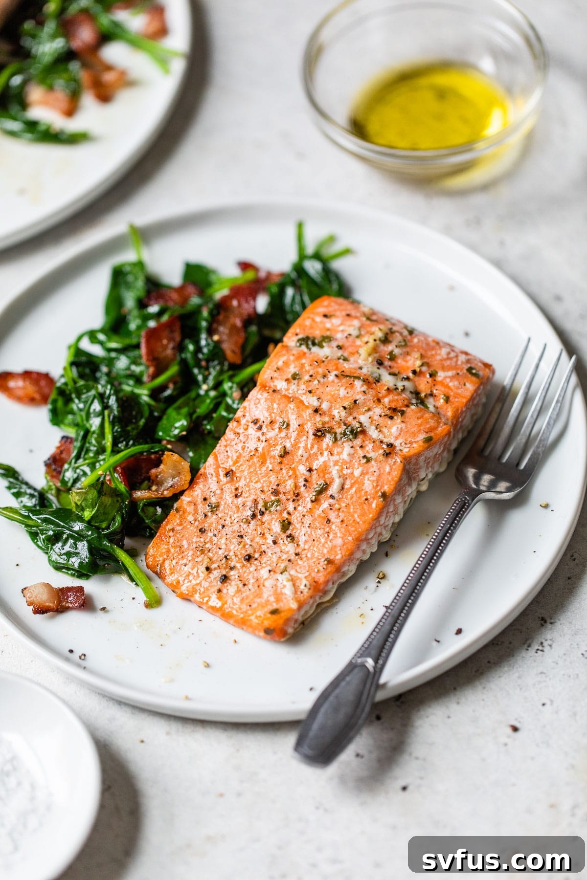 A perfectly cooked salmon fillet served on a bed of fresh spinach, embodying a healthy and nutritious Mediterranean meal.