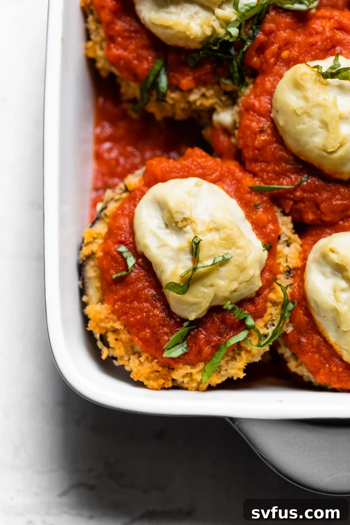 A beautifully layered vegan eggplant parmesan casserole, golden brown and bubbling, ready to be served