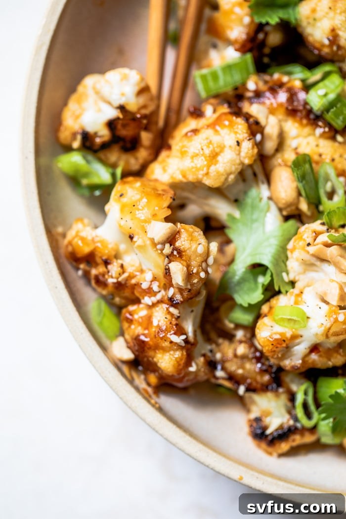 Delicious and spicy Kung Pao Cauliflower garnished with fresh herbs and peanuts