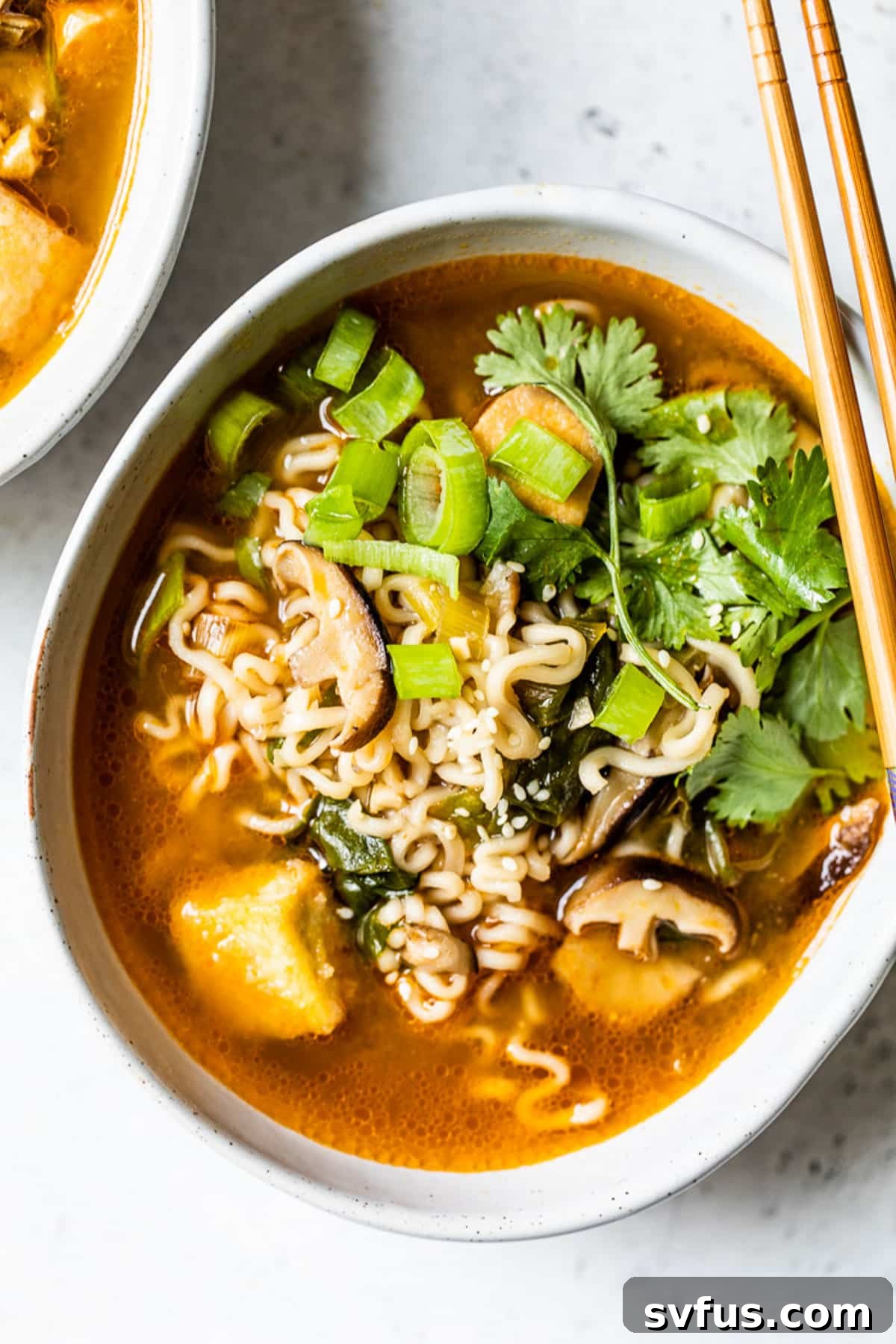 overhead view of a bowl of vegan ramen with chopsticks on top, ready to eat.