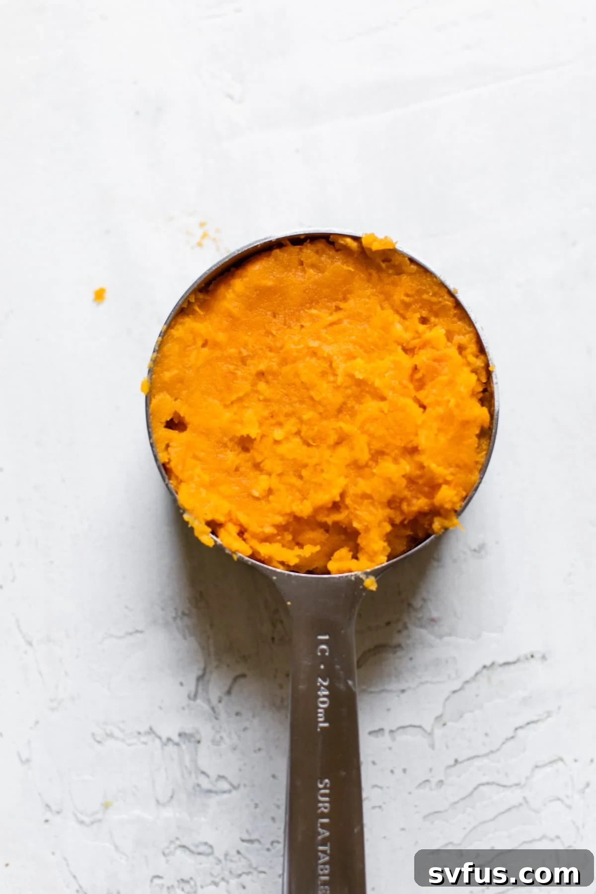 Perfectly mashed sweet potato in a measuring cup, ready for the pie filling.