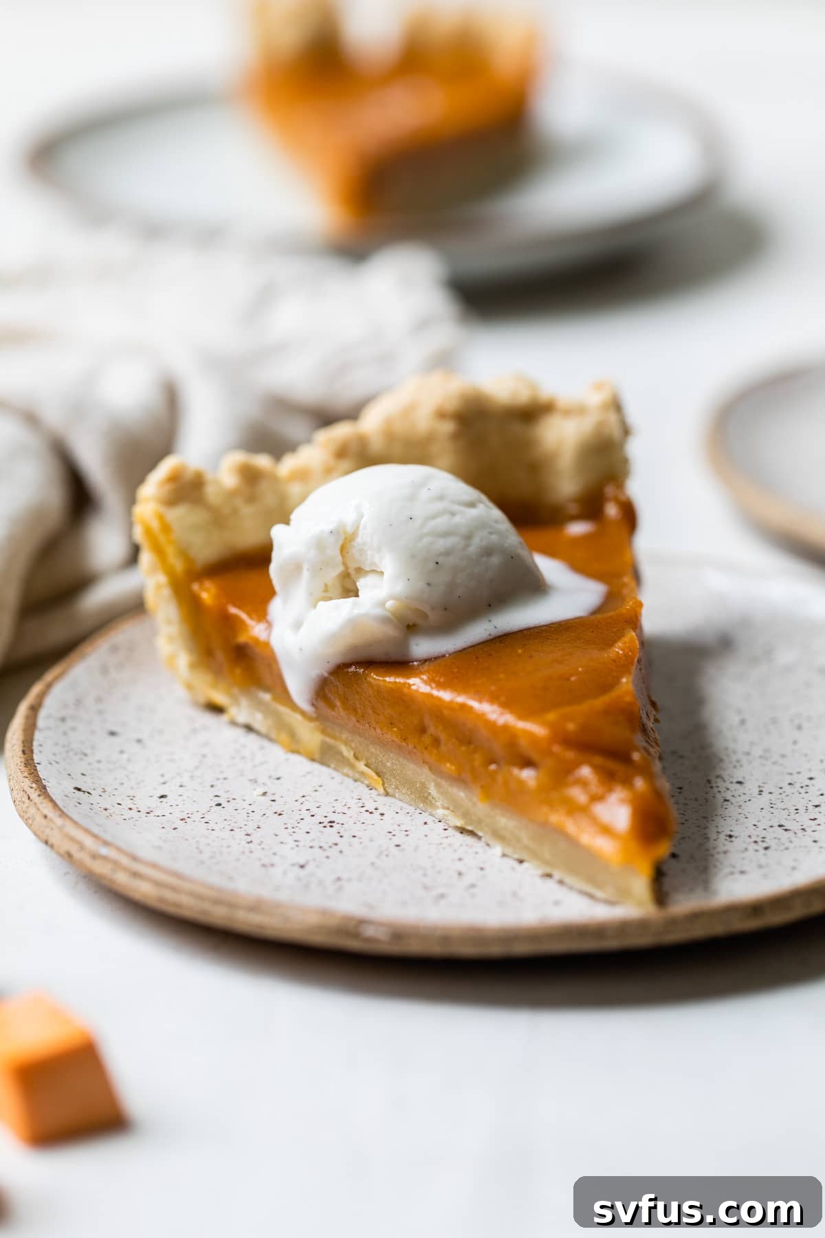 A perfectly sliced piece of Vegan Sweet Potato Pie on a white plate, showcasing its creamy texture.