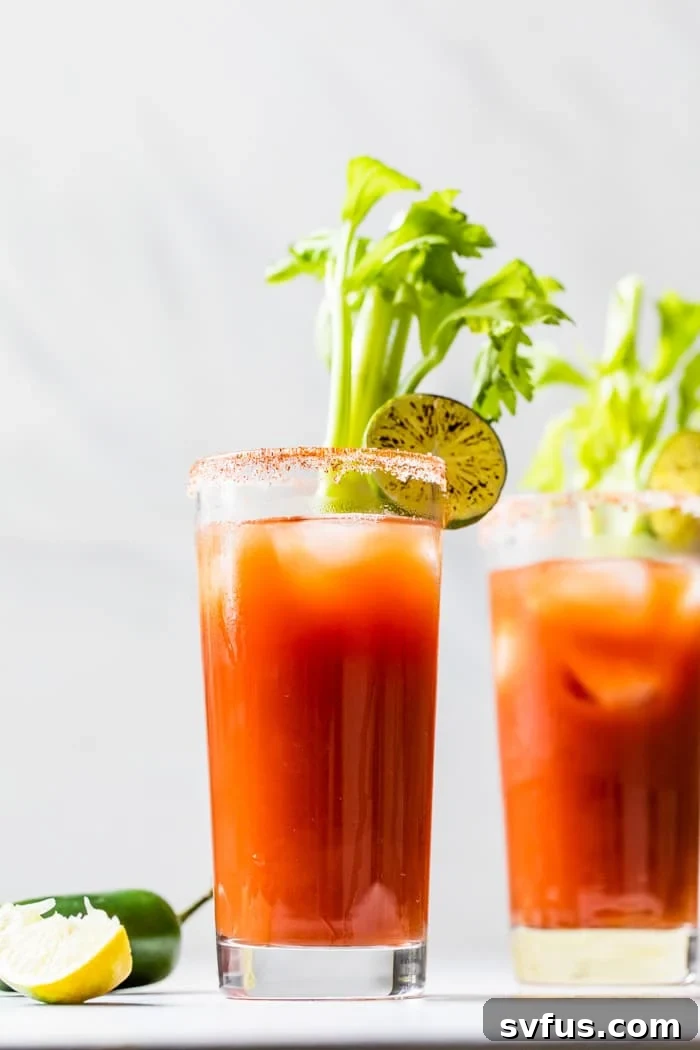 Skinny Tequila Bloody Mary, garnished with a torched lime, in a tall glass with ice.