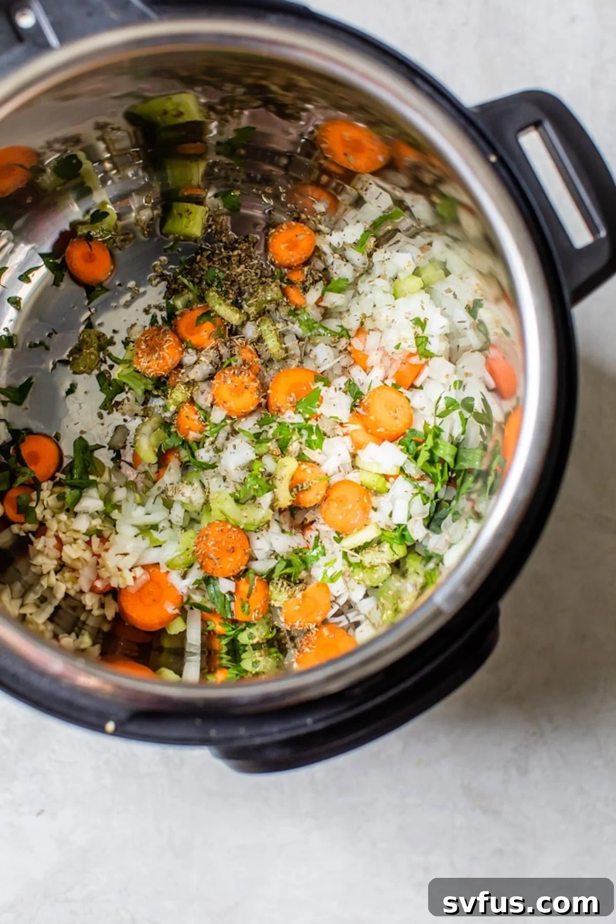 The process of sautéing onions, garlic, carrots, and celery in the heated Instant Pot liner, creating an aromatic foundation for the vegetable soup.