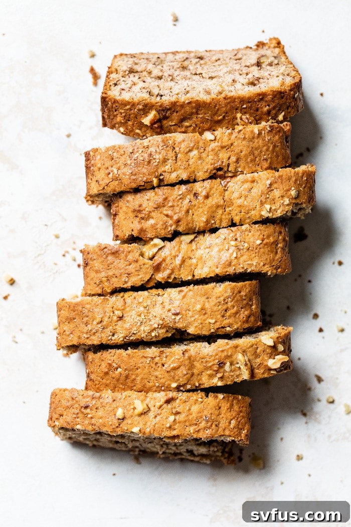 Close-up of freshly baked vegan banana bread slices stacked, showing moist texture and walnuts