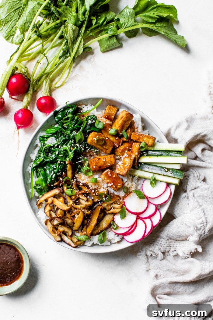 a bowl of bibimbap made with tofu, mushrooms and spinach