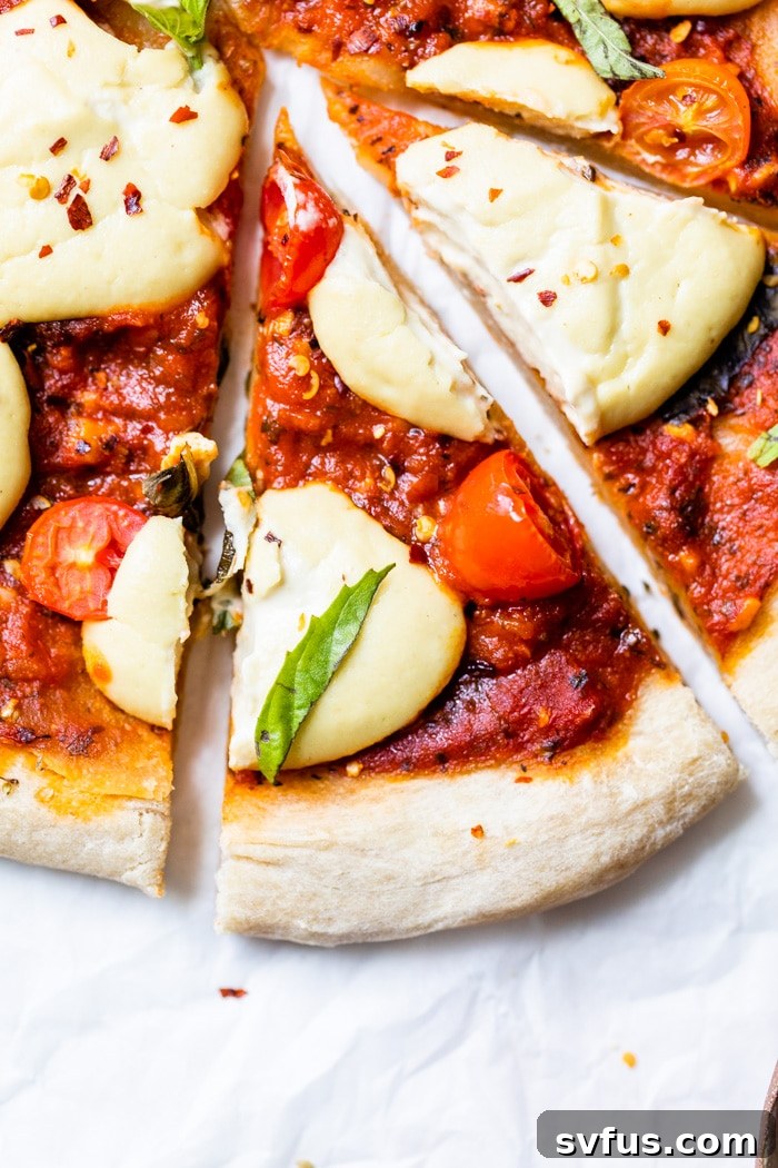 A perfectly sliced piece of vegan pizza, showing off its cheesy texture and toppings.