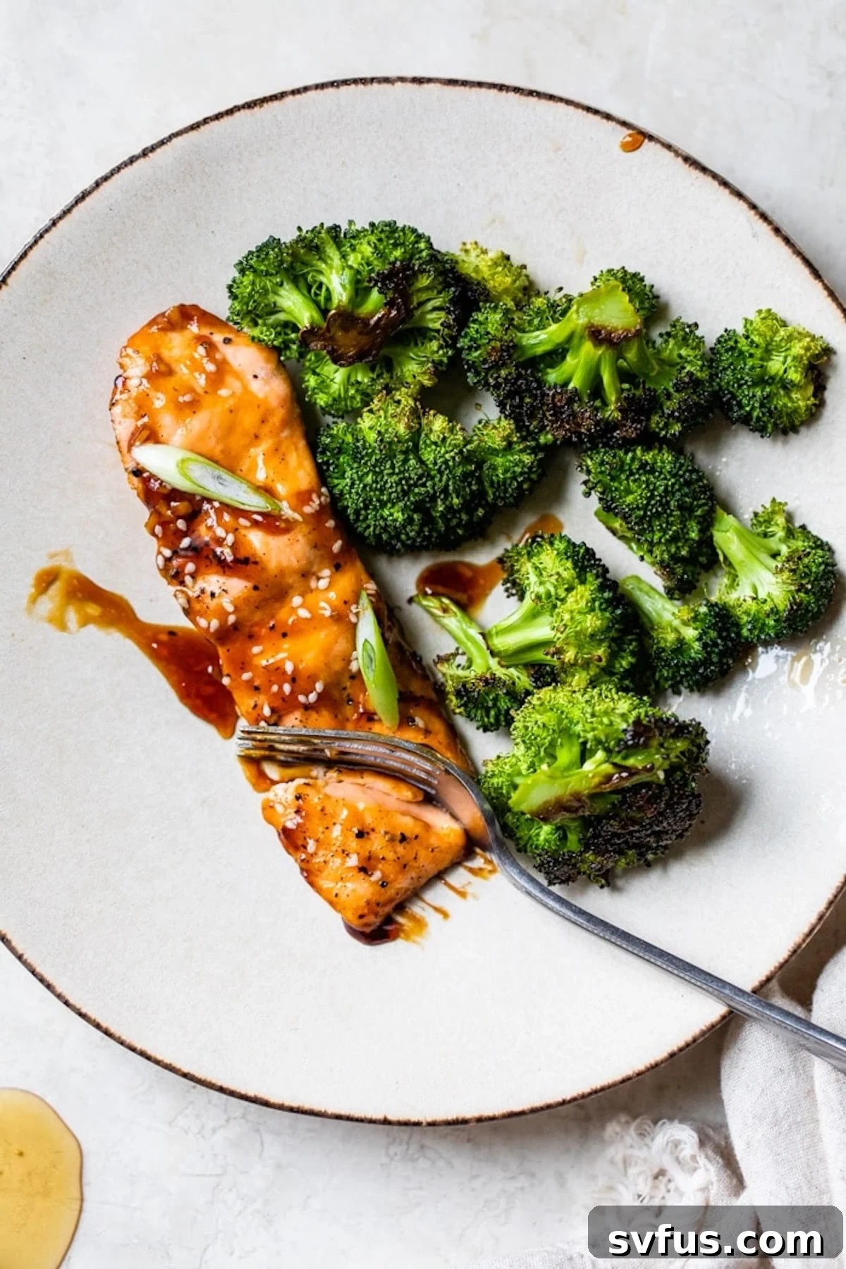 marinated salmon on a plate next to some broccoli