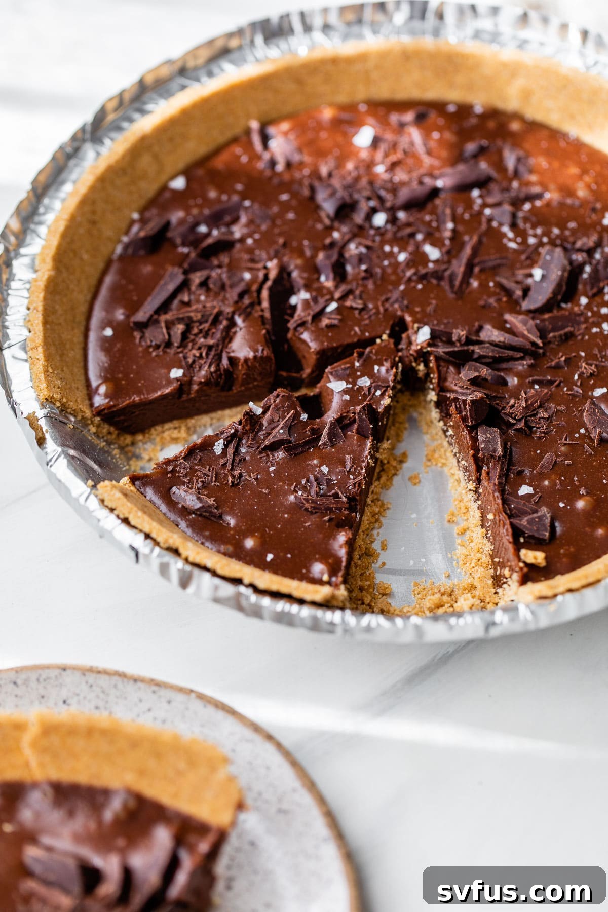 A completed no-bake chocolate pie resting in an aluminum pie pan, chilling and setting beautifully.