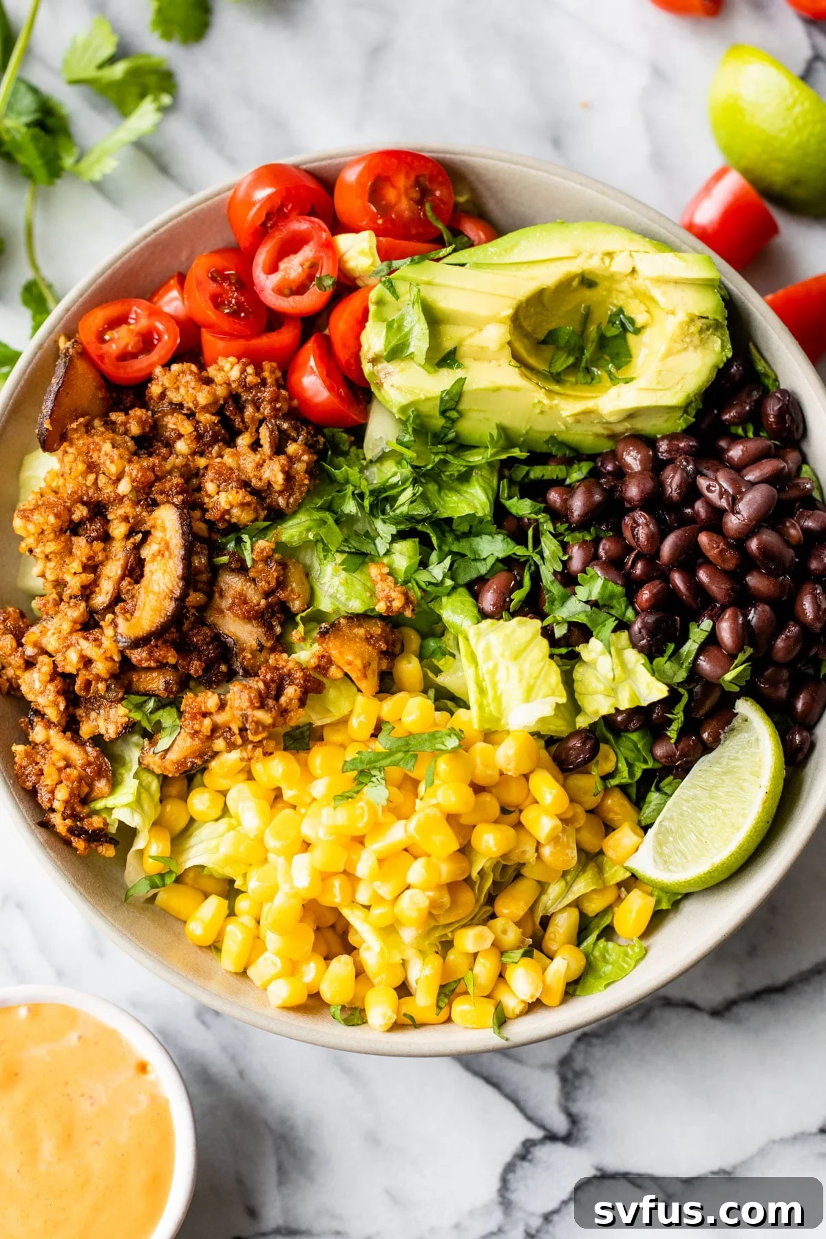 A vibrant and appetizing Vegan Taco Salad artfully arranged in a rustic bowl, showcasing the rich texture of walnut taco meat, surrounded by fresh black beans, golden corn kernels, ripe tomatoes, and creamy avocado slices, ready to be enjoyed.