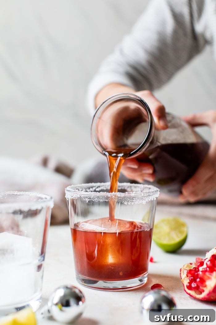 Pouring a Pomegranate Margarita into a glass