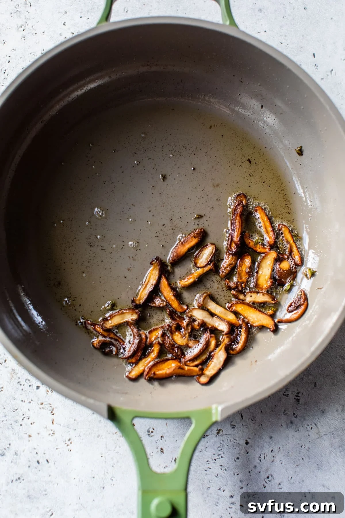 Close-up of golden brown, crispy pan-fried mushrooms in a skillet, ready to be added to the soup.