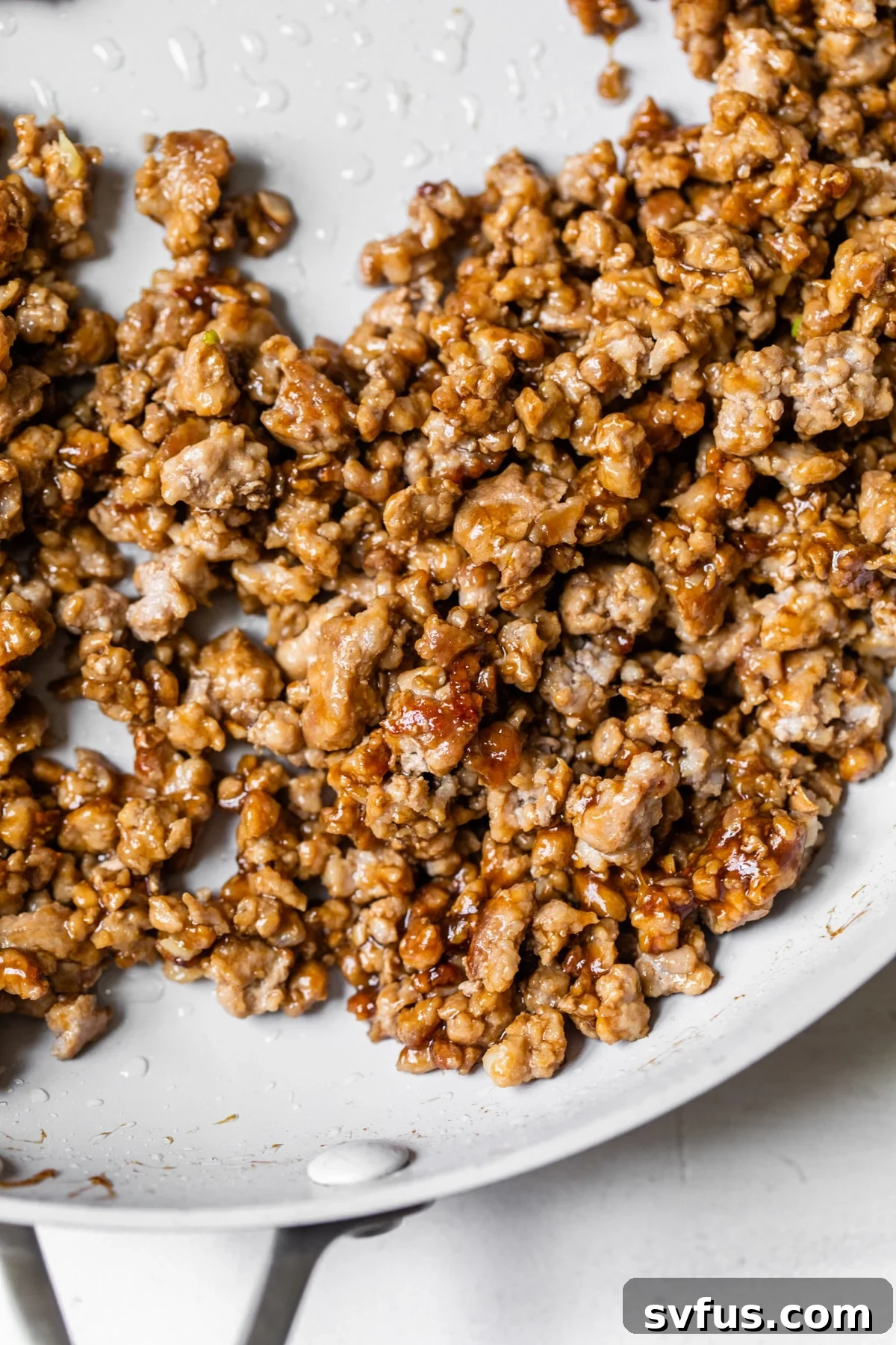 Ground pork glistening with a rich, sticky marinade in a skillet, ready to be served in the Banh Mi Bowl.