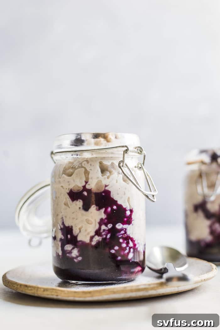 A delectable bowl of Cinnamon Blueberry Rice Pudding, featuring creamy rice pudding infused with cinnamon and topped with a luscious blueberry compote. A perfect make-ahead vegan breakfast from thealmondeater.com.