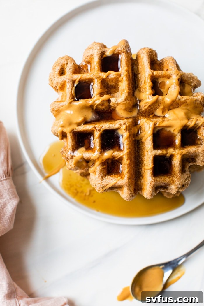 Delicious eggless waffles generously topped with creamy peanut butter and sweet maple syrup, promising a perfect weekend breakfast treat. This easy and healthy peanut butter waffle recipe will have you craving waffles every weekend!