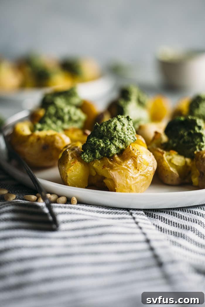 Crispy Pesto Smashed Potatoes, beautifully golden and topped with a fresh, healthy kale pesto. An ideal side dish or a versatile base for a savory vegan breakfast.