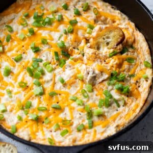 Hot crab dip served in a black skillet, ready for dipping.