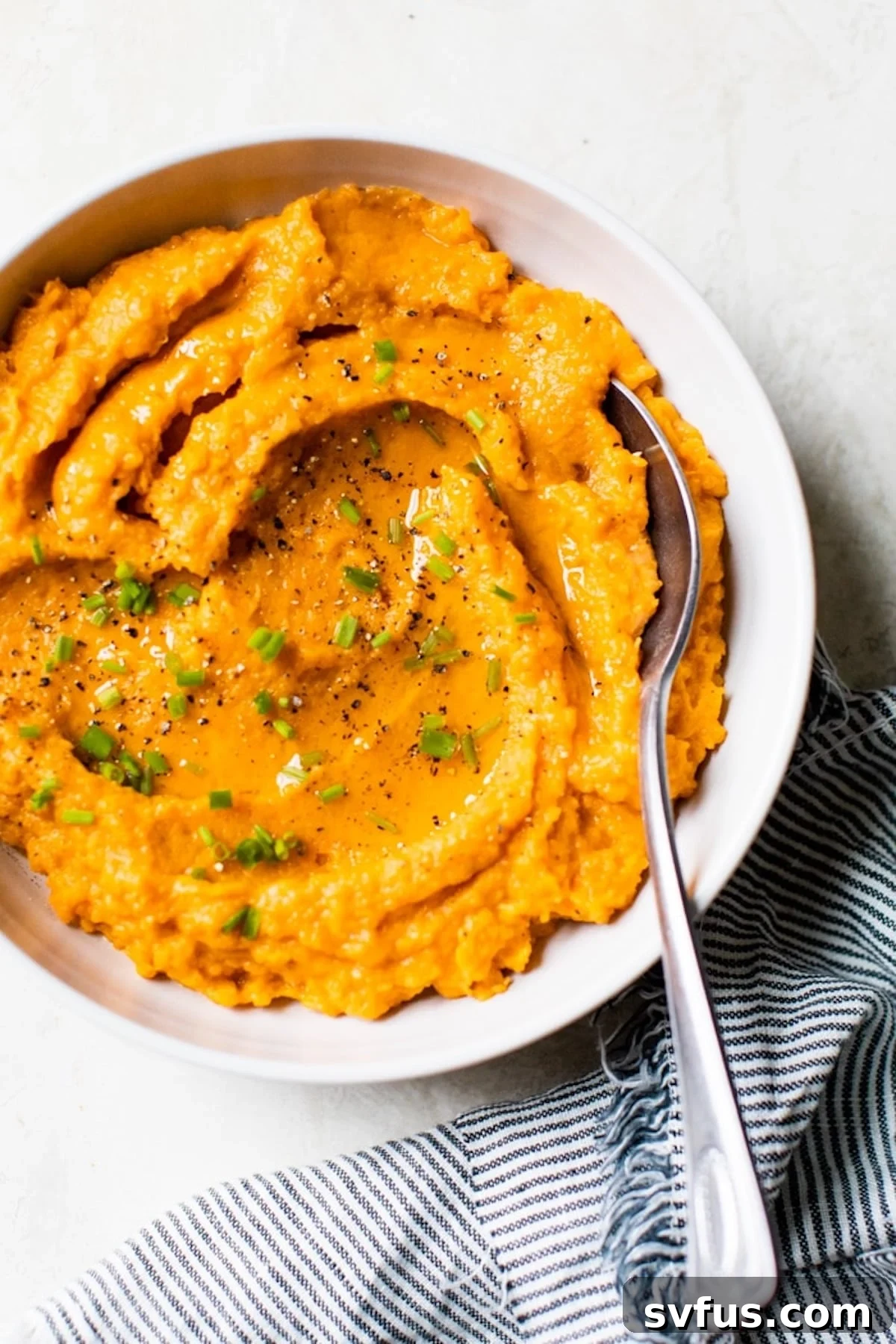 A beautifully presented bowl of creamy savory mashed sweet potatoes, garnished with fresh herbs, ready to be served as a healthy and satisfying side dish.